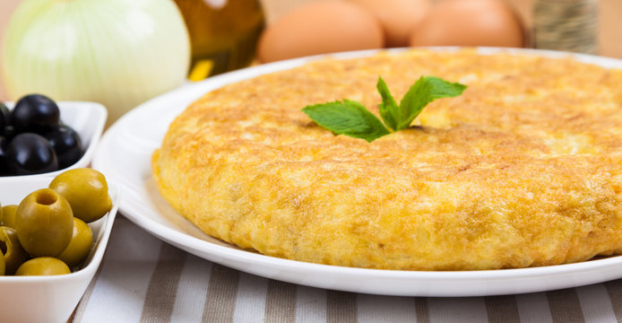 Spanish tortilla (omelette) in a plate, and some ingredients