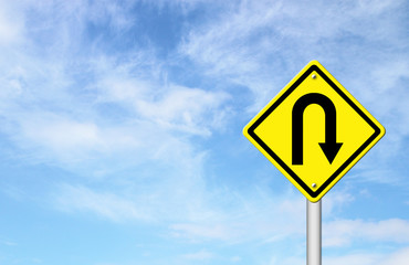 Yellow warning sign u-turn roadsign with blue sky background