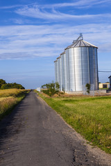 four silver silos in corn field