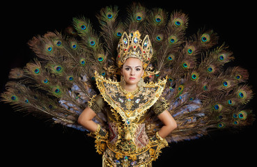 dancer in a golden dress with peacock feathers
