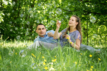 Couple in the woods blow bubbles