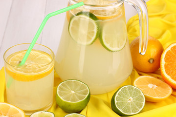 Citrus lemonade in glass and pitcher of citrus around