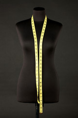 empty black mannequin with measuring tape isolated on black