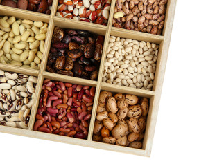 Diverse beans in wooden box sections isolated on white