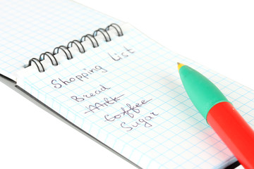 shopping list in a notebook on white background close-up