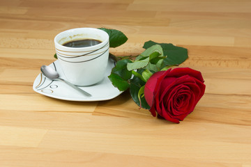 Cup of coffee and red rose on the table