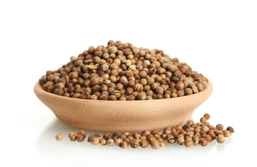Heap coriander seeds in clay bowl isolated on white