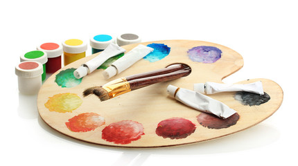 wooden art palette with paint and brushes isolated on white