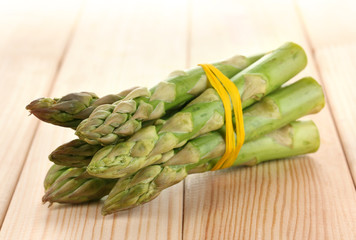 Useful asparagus close-up on wooden table on white background