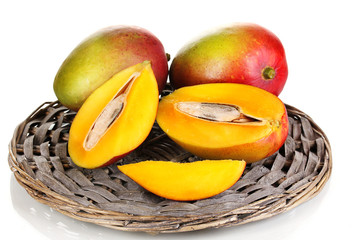 Ripe appetizing mango on wicker cradle isolated on white