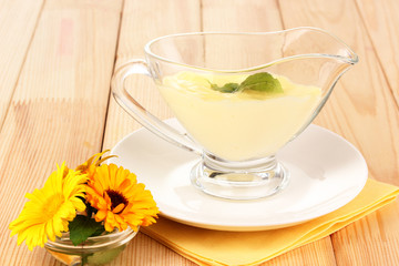 Mayonnaise in bowl on wooden table