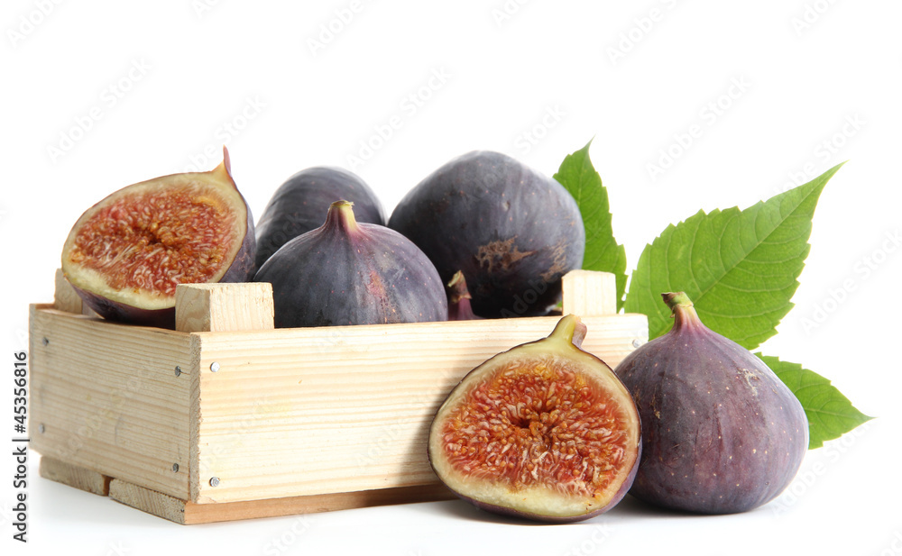 Wall mural ripe sweet figs with leaves in wooden crate isolated on white