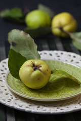 Quitten mit Blättern auf Teller und dahinter