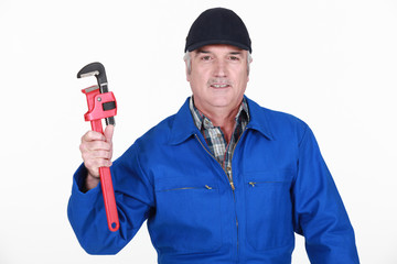 Grey haired man holding wrench