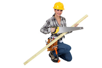 A female carpenter with a handsaw.