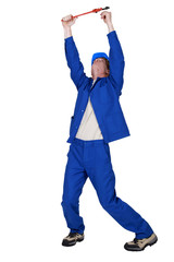 Plumber with wrench reaching into the air
