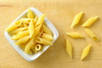 Several penne pasta in a small bowl