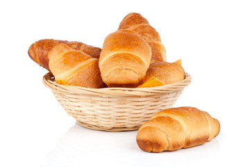 Fresh and tasty croissant in a straw basket, isolated on the whi