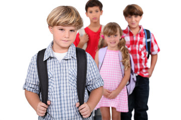 Four schoolchildren with backpacks