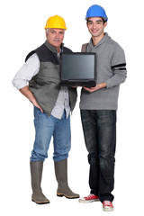 Two manual worker with a laptop.