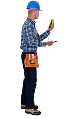 Naklejka premium Tradesman holding a multimeter