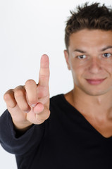 Closeup of young man pointing at something interesting agaisnt a