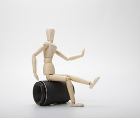 Wooden mannequin and photo lens