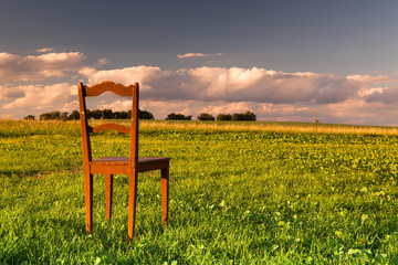 The restless chair on the empty field at sunset