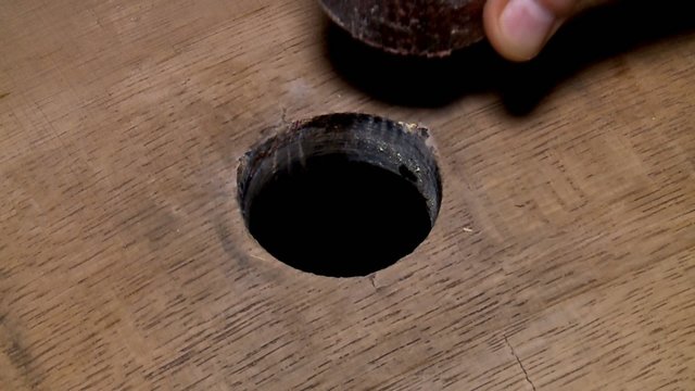 Removing a cork from the oak wine barrels