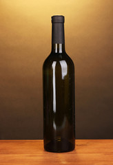 Bottle of great wine on wooden table on brown background