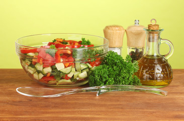 Fresh salad and oil on green background