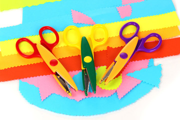 Colorful zigzag scissors with color paper isolated on white