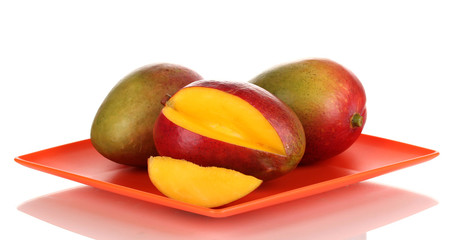 Ripe appetizing mango on red plate isolated on white