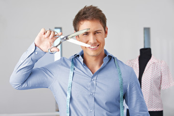 Mann hält Schneiderschere vor Gesicht