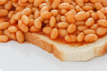 Detail of baked beans on white toast.