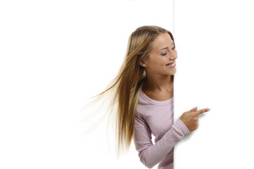 Hübsche Frau zeigt seitlich leeres Plakat