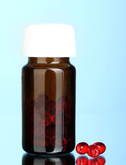 Jar of pills on blue background close-up