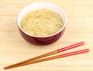asian noodles in bowl on bamboo mat