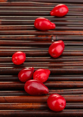 fresh cornel berries on bamboo mat