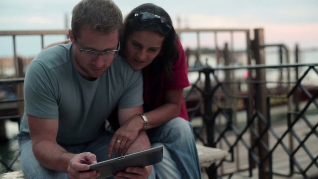 Tourist couple looking at the map in Venice 