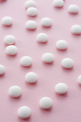 ピンク色の背景に複数の錠剤