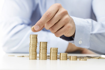 Savings, male hand stacking gold coins