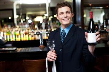 Cheerful executive posing with a bottle of wine