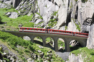 Alpine express passing bridge at St. Gotthard Pass in Switzerlan