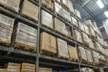 Rows of shelves with boxes in modern warehouse