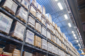 Rows of shelves with boxes in modern warehouse