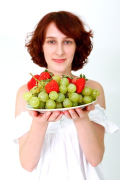 Young woman with fruits on a dish