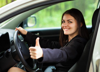 Obraz na płótnie Canvas Happy młoda kobieta w samochodzie z kciuki do góry