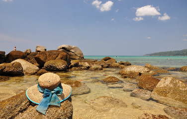 Fototapeta na wymiar Straw hat on the rock. Phuket island, Thailand