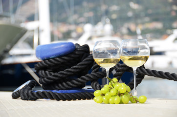 Wineglasses and grapes on the yacht pier of La Spezia, Italy